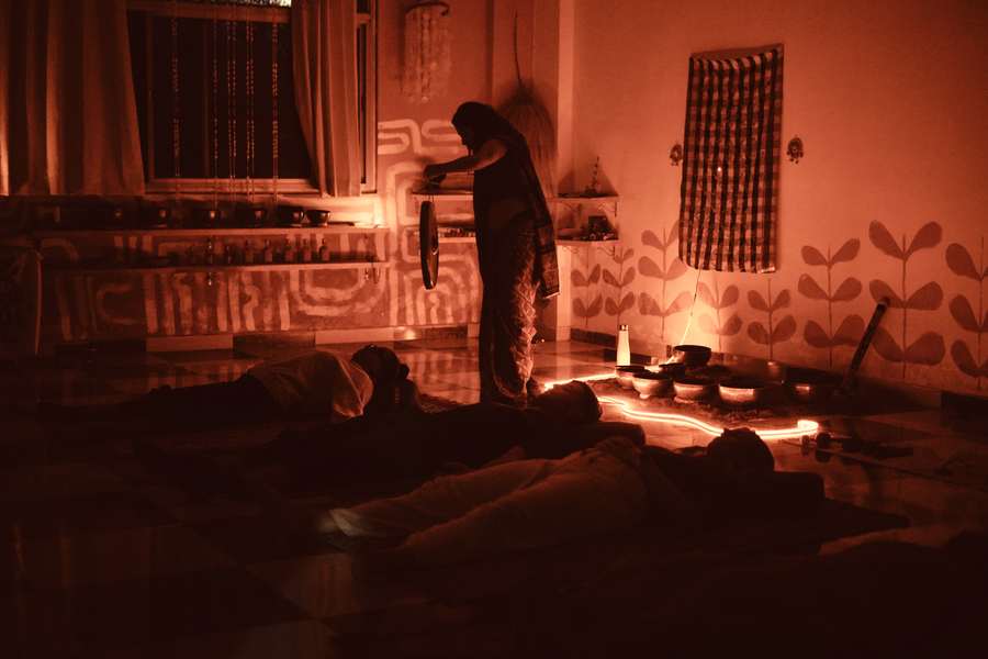 Sound healing gong and singing bowl ceremony session with participants lying on mats